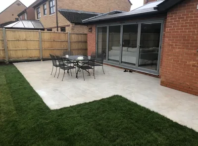 Traditional closeboard fence with vertical boards, concrete posts and gravel boards behind a new porcelain patio