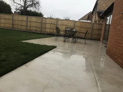 Light porcelain patio with a dining set beside a new lawn