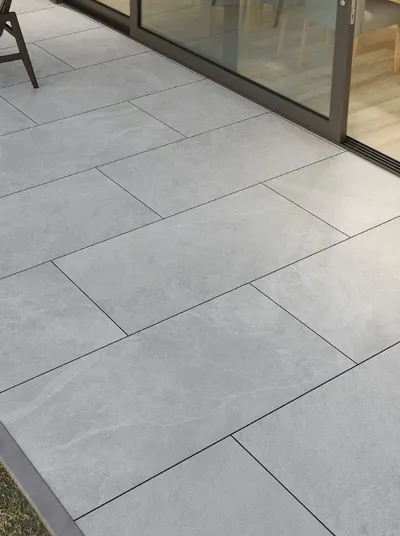 Grey porcelain patio slabs laid outside sliding glass doors
